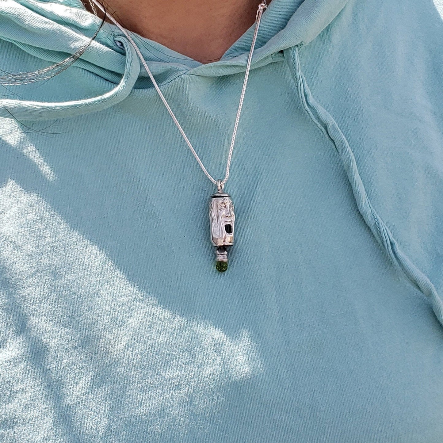 Three face and peridot jangling pendant