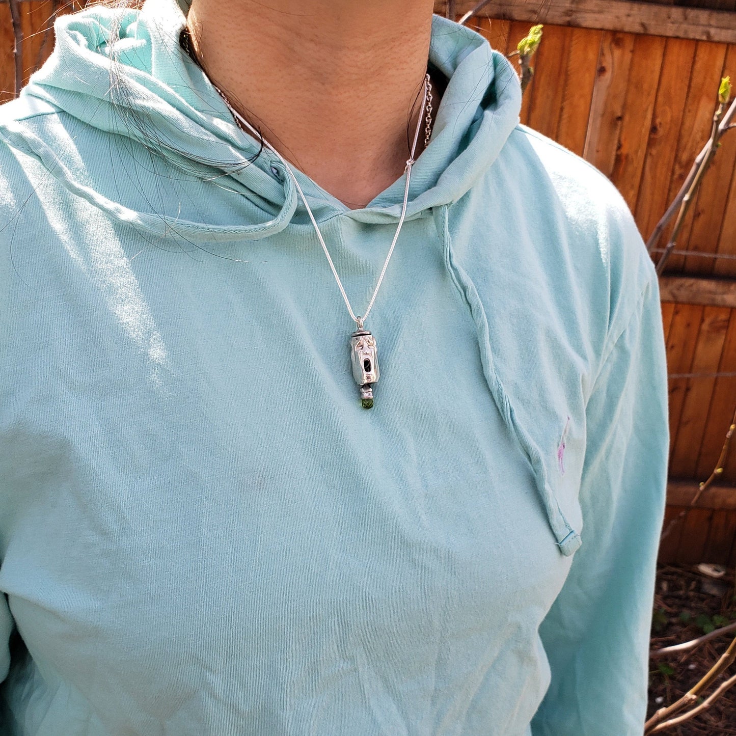 Three face and peridot jangling pendant